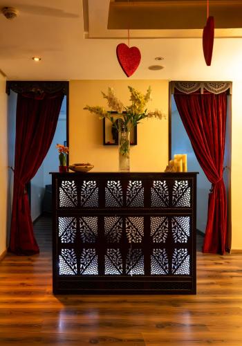 a table with a vase of flowers in a room with red curtains at The Fourteen Luxury Boutique Hotel in Casablanca