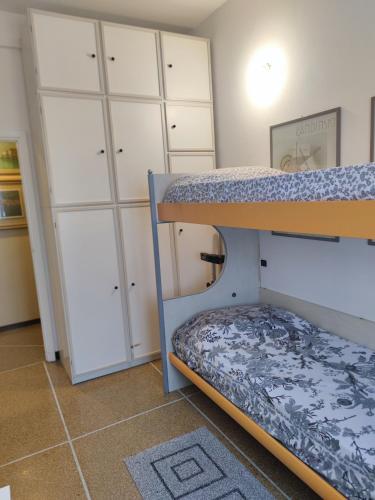1 dormitorio con litera y armarios blancos en Le clarisse, en Rapallo