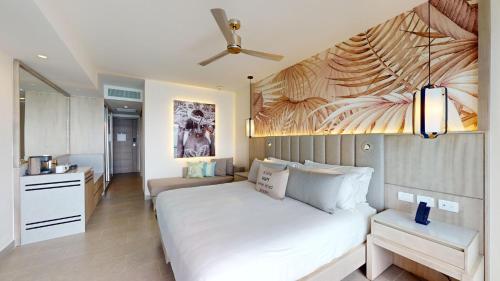 a bedroom with a large white bed and a kitchen at Royalton CHIC Antigua, An Autograph Collection All-Inclusive Resort - Adults Only in Saint Johnʼs