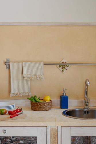 a kitchen counter with a sink and a bowl of fruit at Dimore Opuntia in Spongano