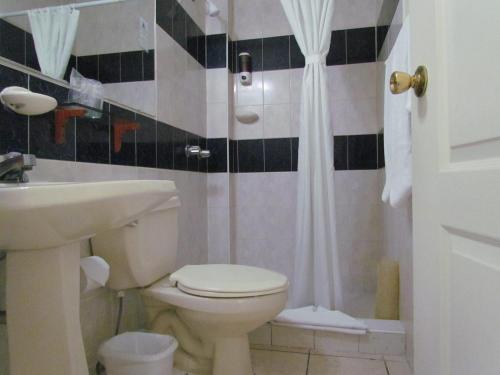 a bathroom with a toilet and a sink and a shower at Hotel Villa Serena Escalon in San Salvador