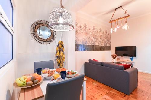 a living room with a couch and a table with fruit on it at Casa Do Raio City Center Ap By Sé Apartamentos in Braga