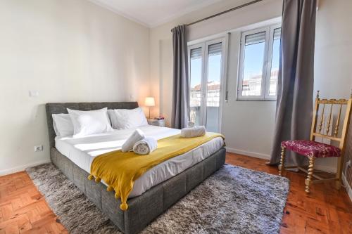 a bedroom with a large bed with a large window at Casa Do Raio City Center Ap By Sé Apartamentos in Braga