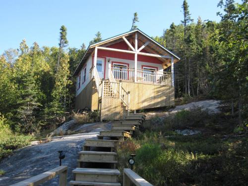 a house on a hill with stairs leading to it at Chalet de la Montagne in Tadoussac