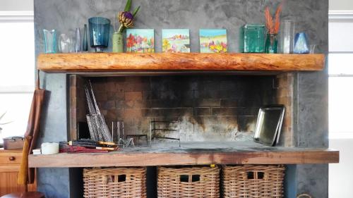a fireplace with wicker baskets on top of it at Jubilee in Buffelsbaai