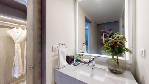 a bathroom with a sink and a vase with a plant at Royalton CHIC Antigua, An Autograph Collection All-Inclusive Resort - Adults Only in Saint Johnʼs