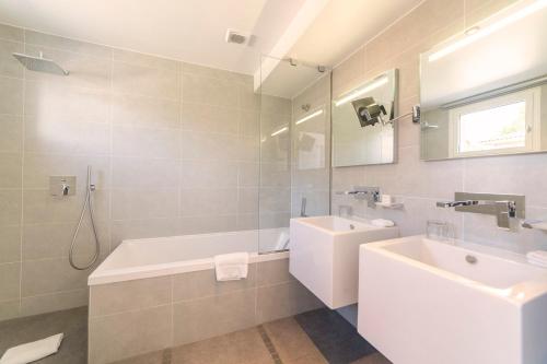 a white bathroom with a tub and a sink at Kube Saint-Tropez in Saint-Tropez