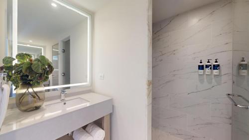 a white bathroom with a sink and a mirror at Royalton CHIC Antigua, An Autograph Collection All-Inclusive Resort - Adults Only in Saint Johnʼs
