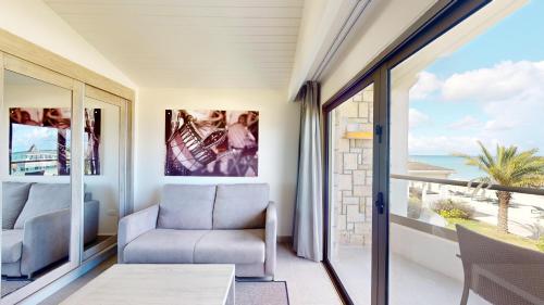 a living room with a chair and a view of the ocean at Royalton CHIC Antigua, An Autograph Collection All-Inclusive Resort - Adults Only in Saint Johnʼs