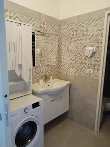 a bathroom with a washing machine and a sink at Casa Acqua Marina in Bisceglie