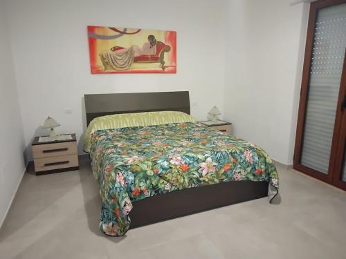 a bedroom with a bed with a floral bedspread at Casa Acqua Marina in Bisceglie