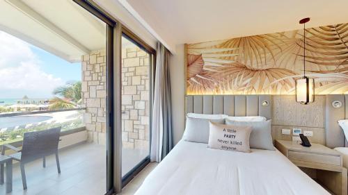 a bedroom with a bed and a view of the ocean at Royalton CHIC Antigua, An Autograph Collection All-Inclusive Resort - Adults Only in Saint Johnʼs