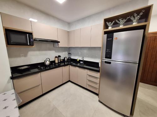 una cocina con nevera y electrodomésticos de acero inoxidable en Casa de praia Brisa das Amendoeiras, en Palhoça