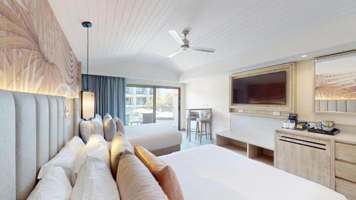a hotel room with a bed and a tv at Royalton CHIC Antigua, An Autograph Collection All-Inclusive Resort - Adults Only in Saint Johnʼs