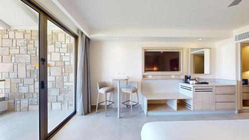 a kitchen with a table and chairs in a room at Royalton CHIC Antigua, An Autograph Collection All-Inclusive Resort - Adults Only in Saint Johnʼs