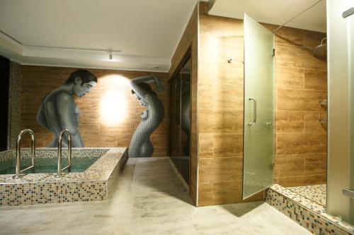 a bathroom with two sinks and a mural of two women at GREEN Which Hotel in Petropavlovsk