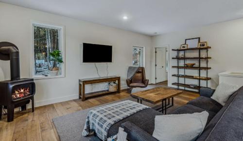 a living room with a couch and a fireplace at Fireplace Woods Club Access - Modern Quechee in Quechee