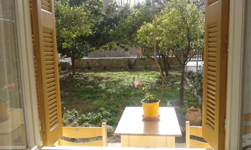 an open window with a table and a view of a yard at Kampos Rooms in Palaiochóra