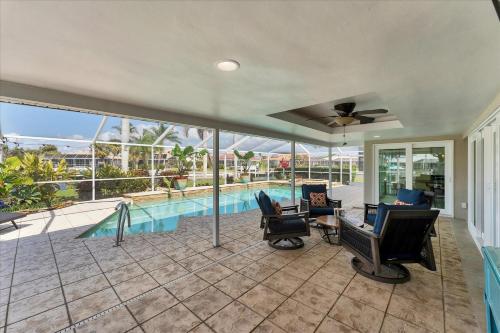 an indoor patio with chairs and a swimming pool at 803 Napoli in Punta Gorda