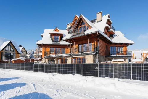 a house covered in snow in front at Good Morning Giewont & JACUZZI in Kościelisko