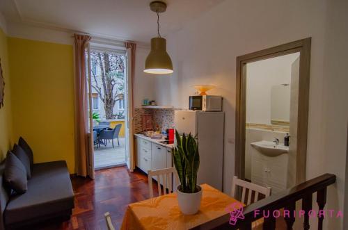 un soggiorno con tavolo e una cucina con frigorifero di Garden Fiore del Ducato a Parma