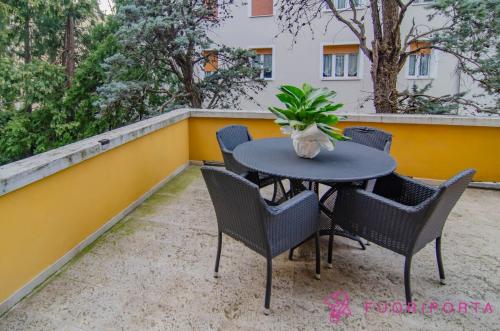 un tavolo con sedie e una pianta sul balcone di Garden Fiore del Ducato a Parma