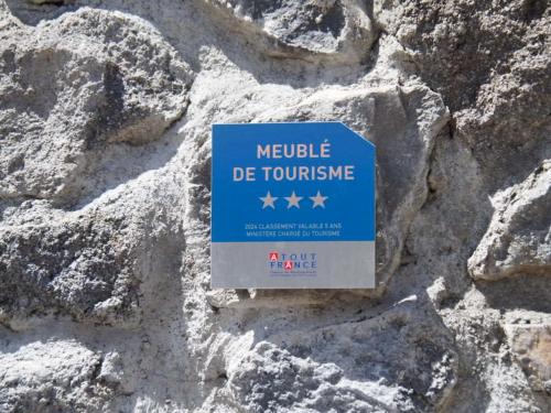 a sign on the side of a stone wall at La Josette - Appartement avec jardin privatif in Cilaos