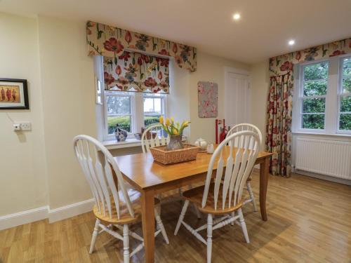 a dining room with a wooden table and chairs at Eagle Glen Cottage in Blairgowrie