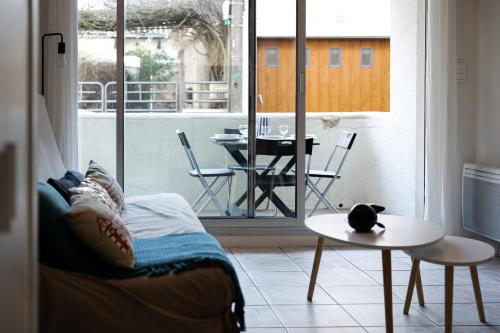 Cette chambre dispose d'un balcon avec un lit et une table. dans l'établissement Grand studio idéalement situe quartier Arago - 2 à 4 personnes, à Les Sables-dʼOlonne