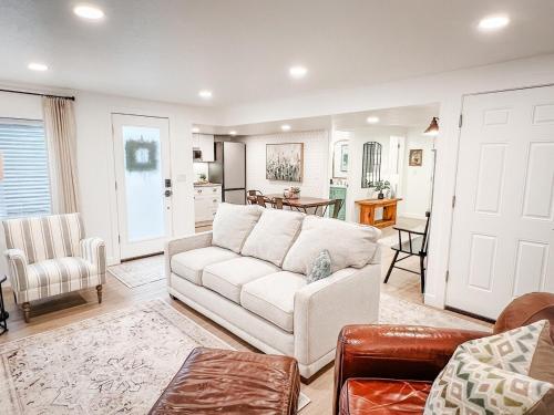 a living room with a white couch and a kitchen at Bright & Cozy Basement Retreat in American Fork