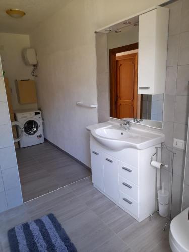 a bathroom with a sink and a mirror at Casa relax Berchida in Capo Comino