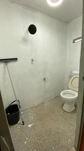 baño con aseo y una luz en la pared en Homestay Jelai, en Gemas