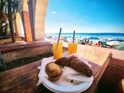 贝瓦尼亚圣彼得Villa Sul Mare的一张桌子,上面放着一盘食物和两杯橙汁