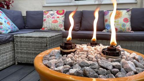 a fire pit with three fires in it in front of a couch at Zip Cottage Sleeps 2-3 climb snowdon zip world in Tanygrisiau