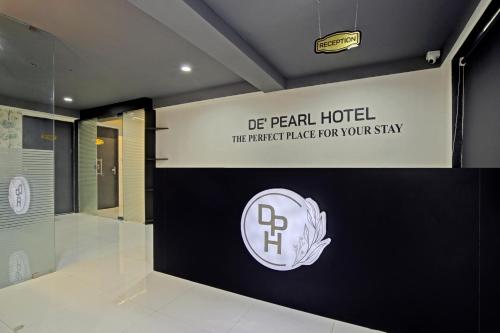 a hotel lobby with a sign on the wall at Collection O De'pearl Hotel in Surat