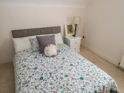 a bedroom with a bed with a floral bedspread at Kivvy Cottage in Carrigallen