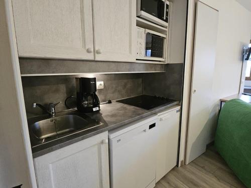 une petite cuisine avec un évier et un micro-ondes dans l'établissement Charmant T2 pour 5 pers. avec balcon, idéalement situé à Avoriaz, proche pistes et commerces - FR-1-314-181, à Avoriaz