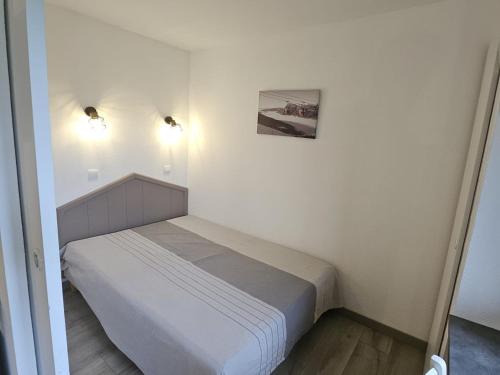 - une petite chambre blanche avec un lit et deux lumières dans l'établissement Charmant T2 pour 5 pers. avec balcon, idéalement situé à Avoriaz, proche pistes et commerces - FR-1-314-181, à Avoriaz
