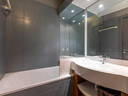 a bathroom with a sink and a tub and a mirror at Charmant 3 pièces, 6 pers, balcon, WiFi, ski-in/ski-out - FR-1-314-155 in Morzine