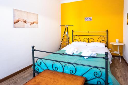 a bedroom with a bed with a yellow wall at Essenza di Zagara, 5min dalle spiagge e porto in Trapani