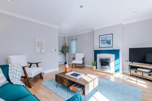 a living room with a blue couch and a fireplace at Charming Townhome Retreat, close to Manchester in Manchester