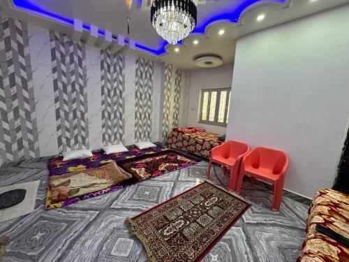 a room with two beds and two red chairs at magician homestay in Prayagraj