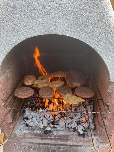 a brick oven with food cooking in it at Barlosh Barony Tpod Lodge Ayrshire, elec jacuzzi, BBQ, Firepit, Pizza Oven, indoor outdoor terrace with amazing views, spacious inside and out in Ochiltree