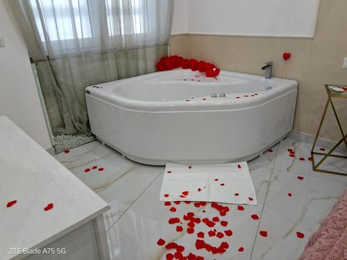 a bathroom with a white tub with red hearts on the floor at Maison De luxe in Pompei