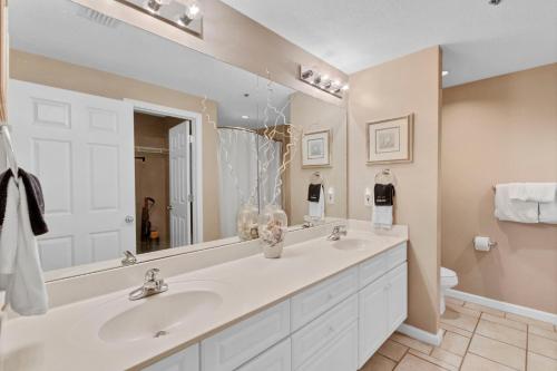 ein Badezimmer mit zwei Waschbecken und einem großen Spiegel in der Unterkunft 3BR 4BA Ground Floor Gulf Getaway in Gulf Shores