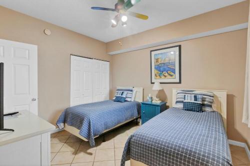 ein Schlafzimmer mit zwei Betten und einem Deckenventilator in der Unterkunft 3BR 4BA Ground Floor Gulf Getaway in Gulf Shores