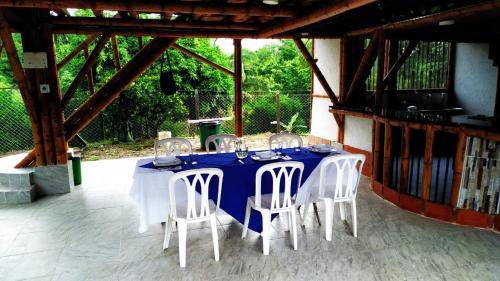 a table with white chairs and a blue table cloth at Hospedaje piedras de agua in Santa Marta