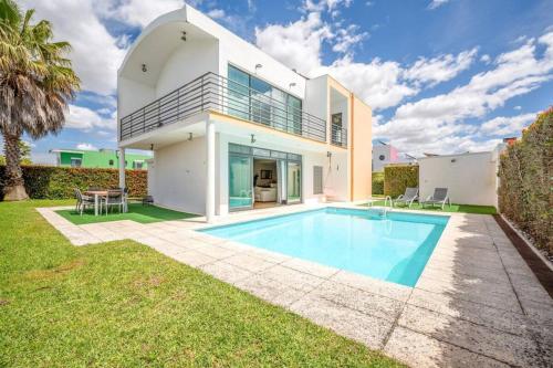 a house with a swimming pool in the yard at Moradia Palmela Village in Quinta do Anjo
