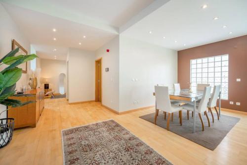 a dining room and living room with a table and chairs at Moradia Palmela Village in Quinta do Anjo