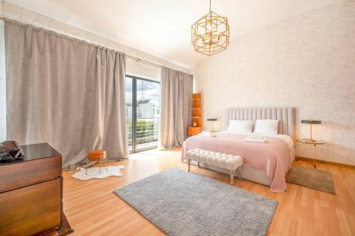 a bedroom with a bed and a dresser and a tv at Moradia Palmela Village in Quinta do Anjo